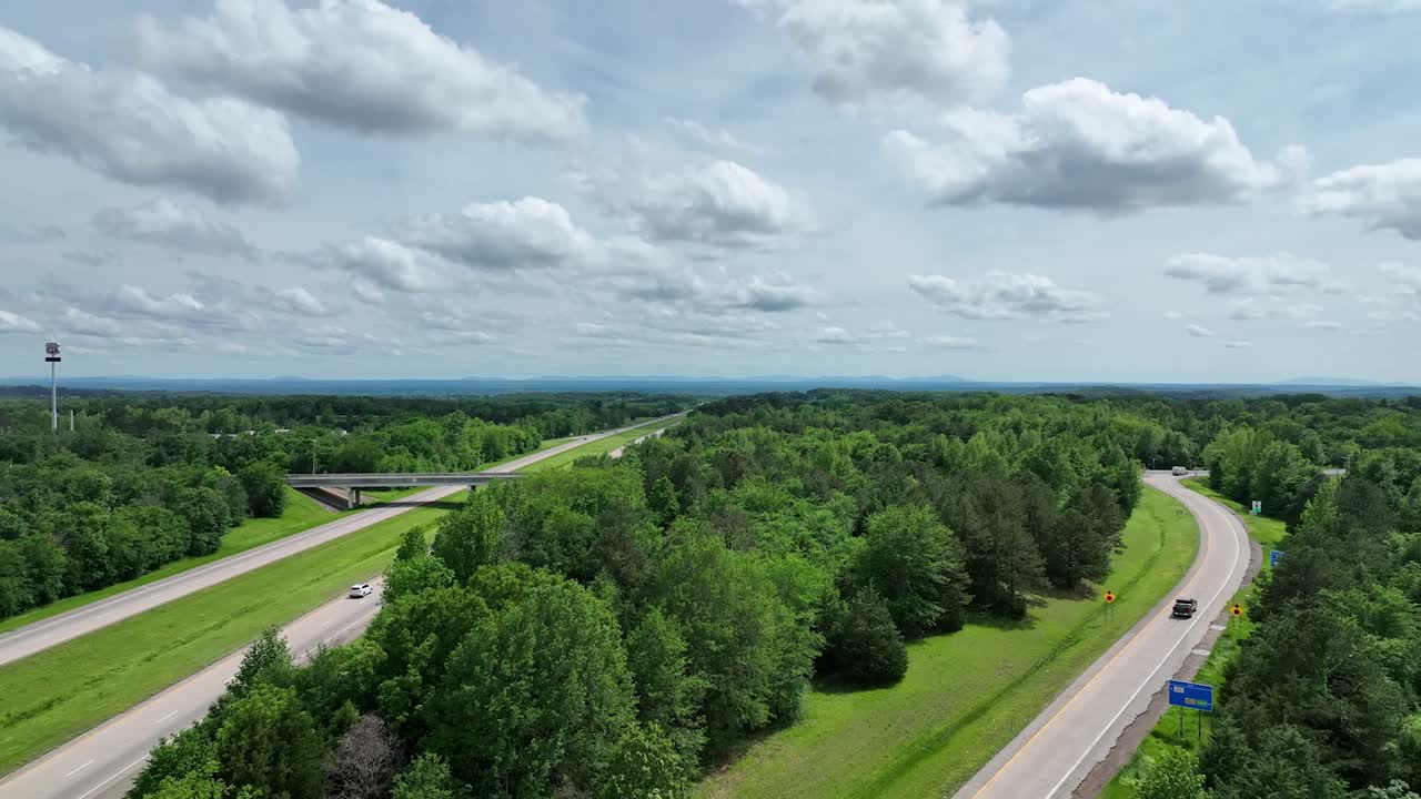 무성한 녹색 숲을 가로지르는 고속도로의 공중 전망