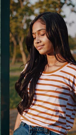 young girl enjoying golden hour portrait session, expressing genuine emotions through varied poses and candid moments in sunlit park setting with natural, soft lighting and relaxed demeanor