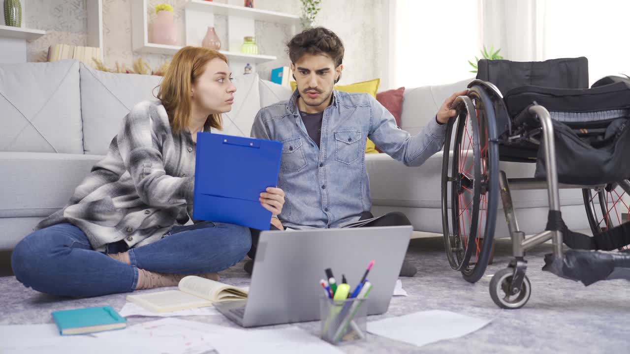 en casa, el hombre discapacitado y su novia están estudiando para las lecciones.
