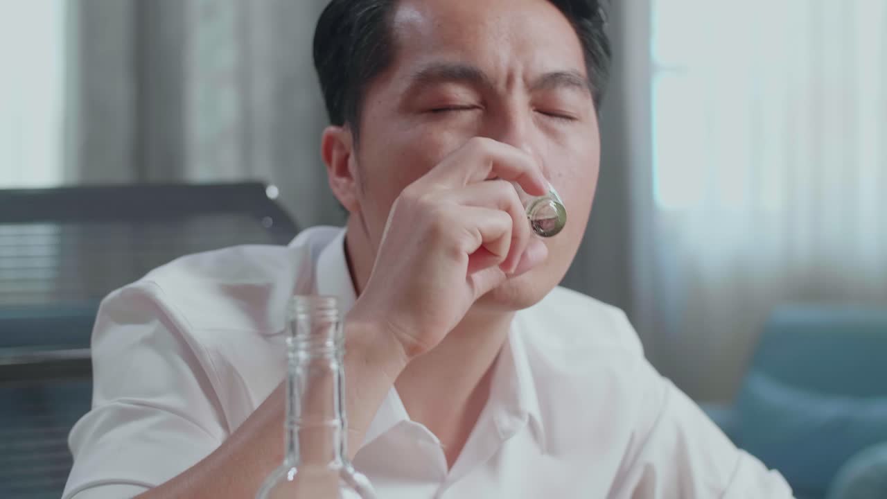 술에 취한 아시아인 남자가 보드카를 마시고 집에서 잠을 자고