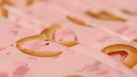 ham italian mordatella, man slices of traditional italian antipasti mortadella sausage on a wooden cutting board, close up macro of chicken or turkey jamon, fat breakfast dish.