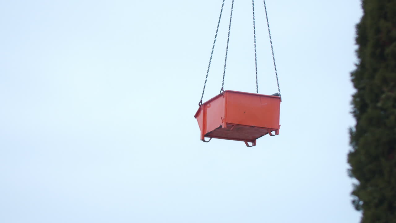 contenedor naranja en el aire en movimiento de un sitio de construcción