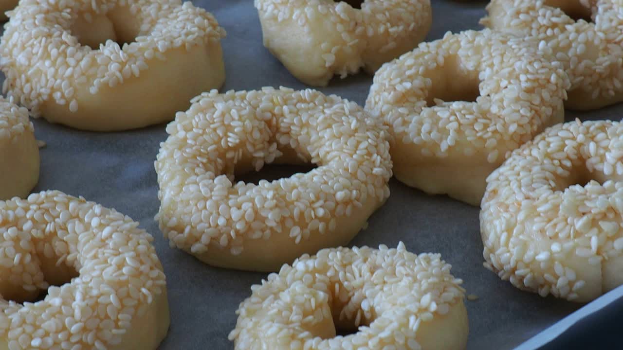 Close-up sesame seeds stuck to the dough, tiny bagels with sesame seeds,