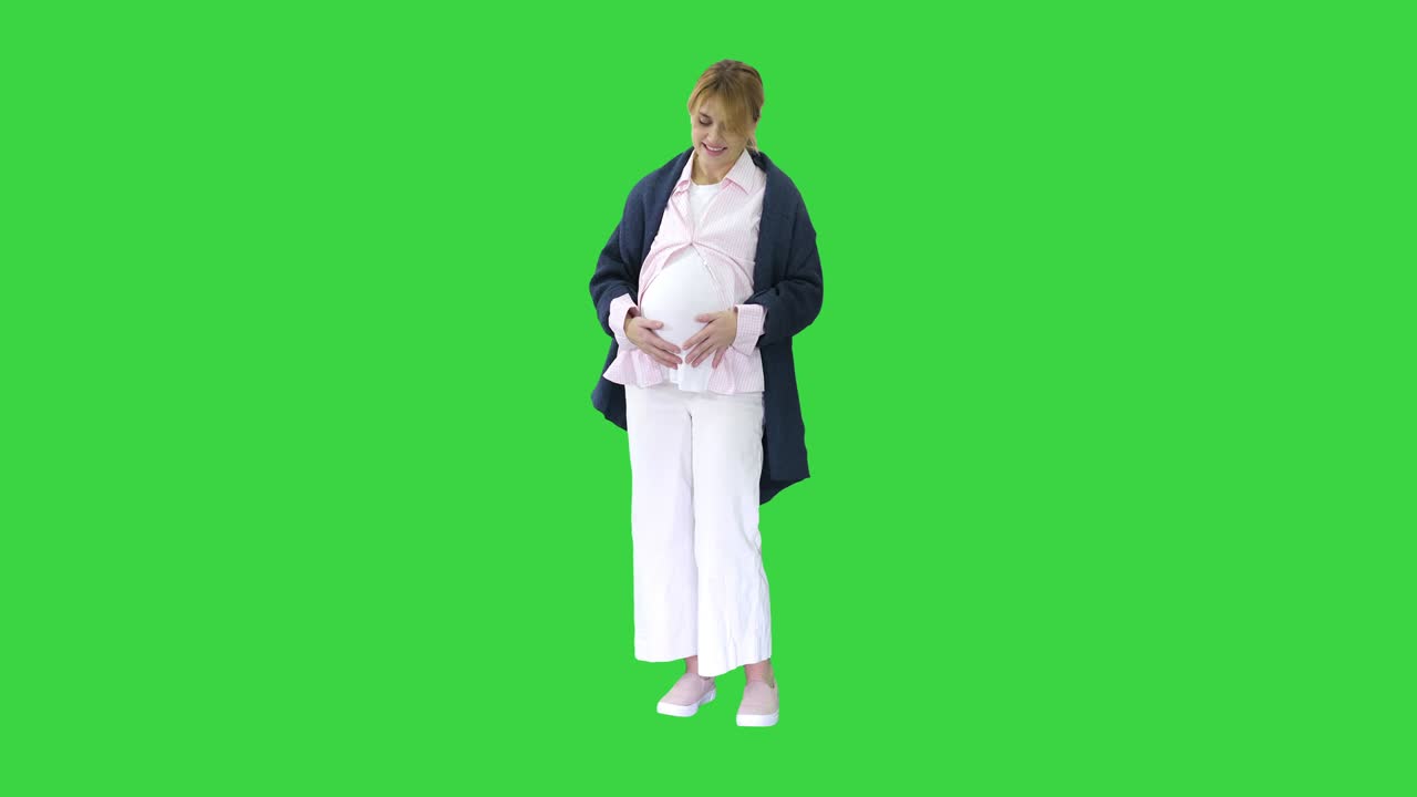 초록색 스크린, 크로마 키에서 배를 만지는 임신한 여성
