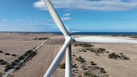 Stationary-drone-shot-of-spinning-wind-turbine