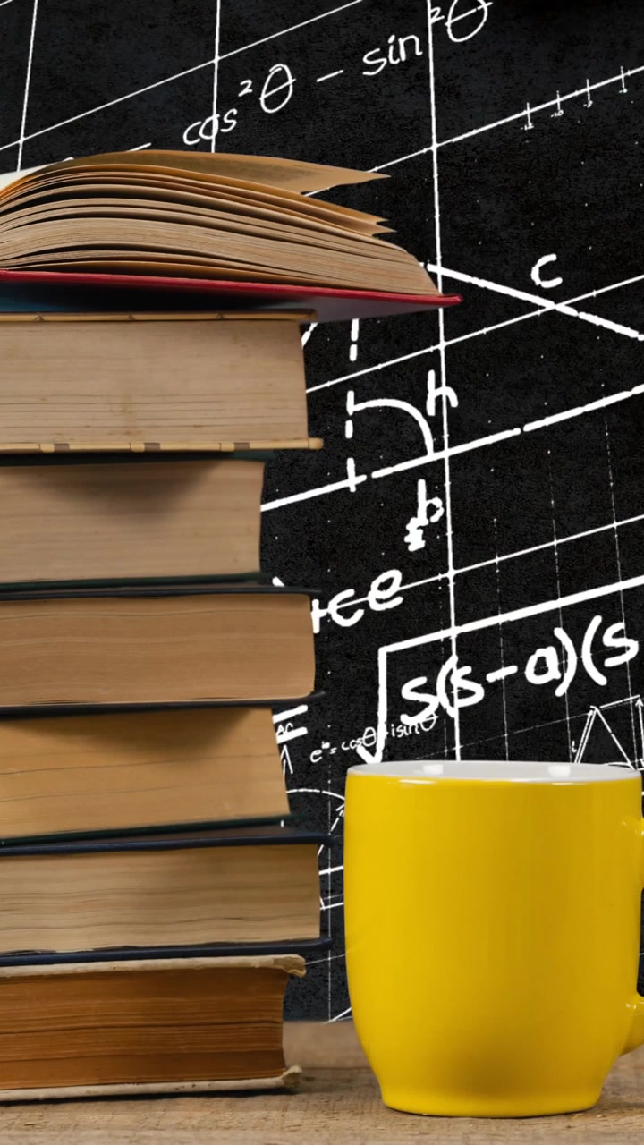 Tazza accanto a una pila di libri e equazioni matematiche