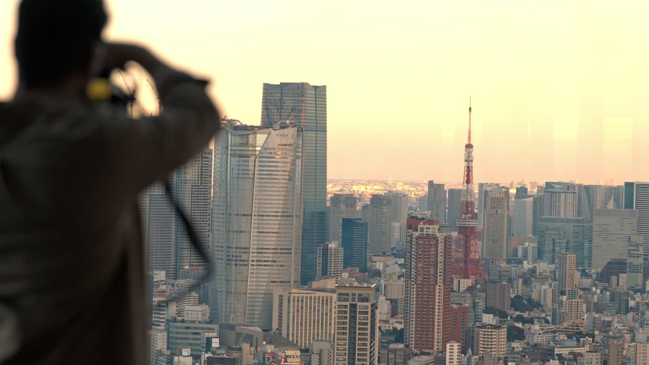 A passionate photographer frames the perfect shot of Tokyo Tower bathed in the warm hues of sunset.