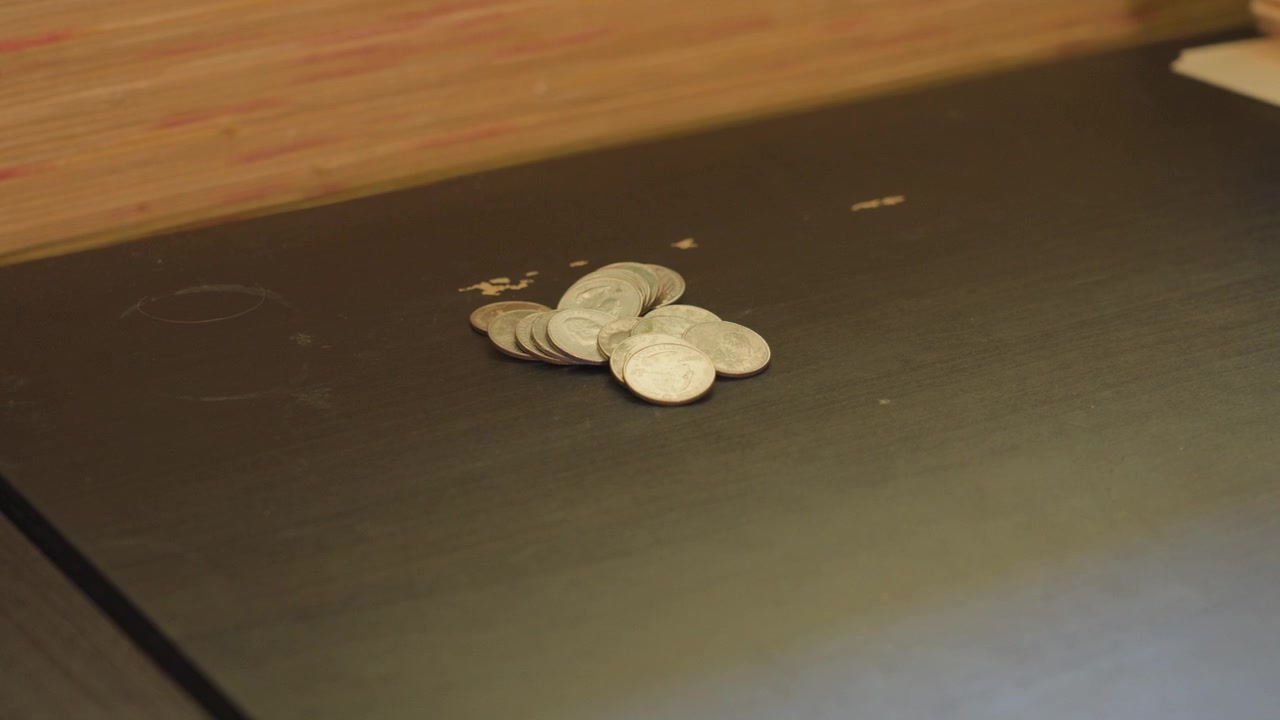 Medium Shot of a pile of quarters on a desk.