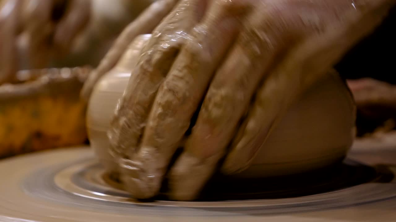 Potter is making clay pot on the potter's wheel