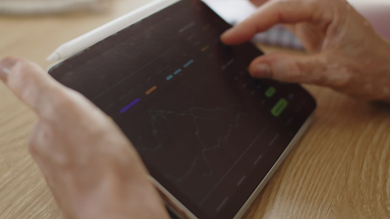Hands of Businessperson Looking at Charts on Digital Tablet