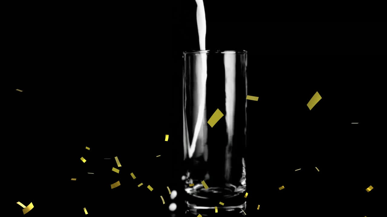 Animation of confetti over glass with liquid on black background