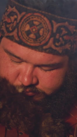 ecstatic obese man taps shamanic drum doing old mystical ritual in ail closeup. shamanic traditions of siberia. amazing altai ethnic culture