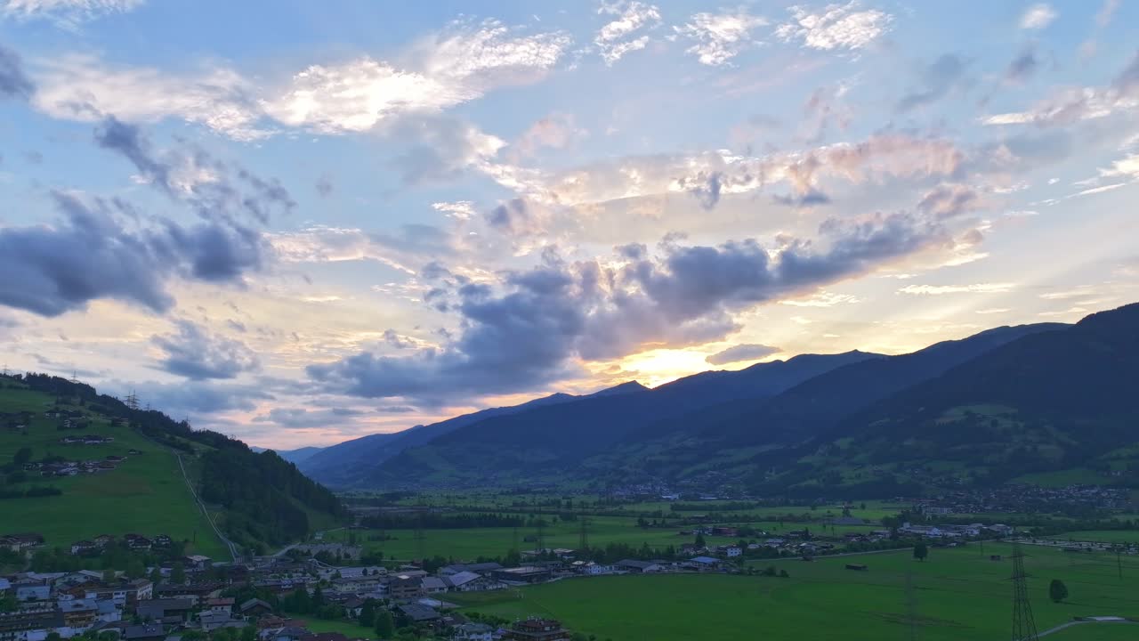 색과 어두운 구름이 정착촌과 초록색 계곡을 가로질러 움직입니다.