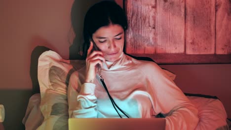 mujer feliz caucásica trabajando con una computadora portátil y hablando en el teléfono celular