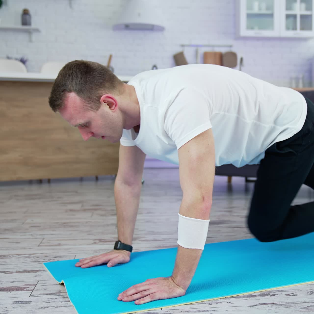 Quarantine man doing exercise indoor. Lifestyle strong man training his body in home at the special mat