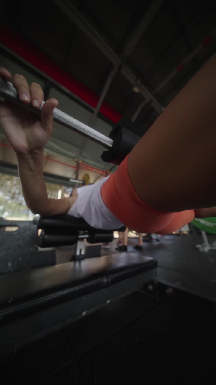 Woman doing bench press in gym