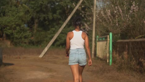 Young-Indian-women-walking-on-the-way-in-slow-motion-into-the-woods---towards-her-dog