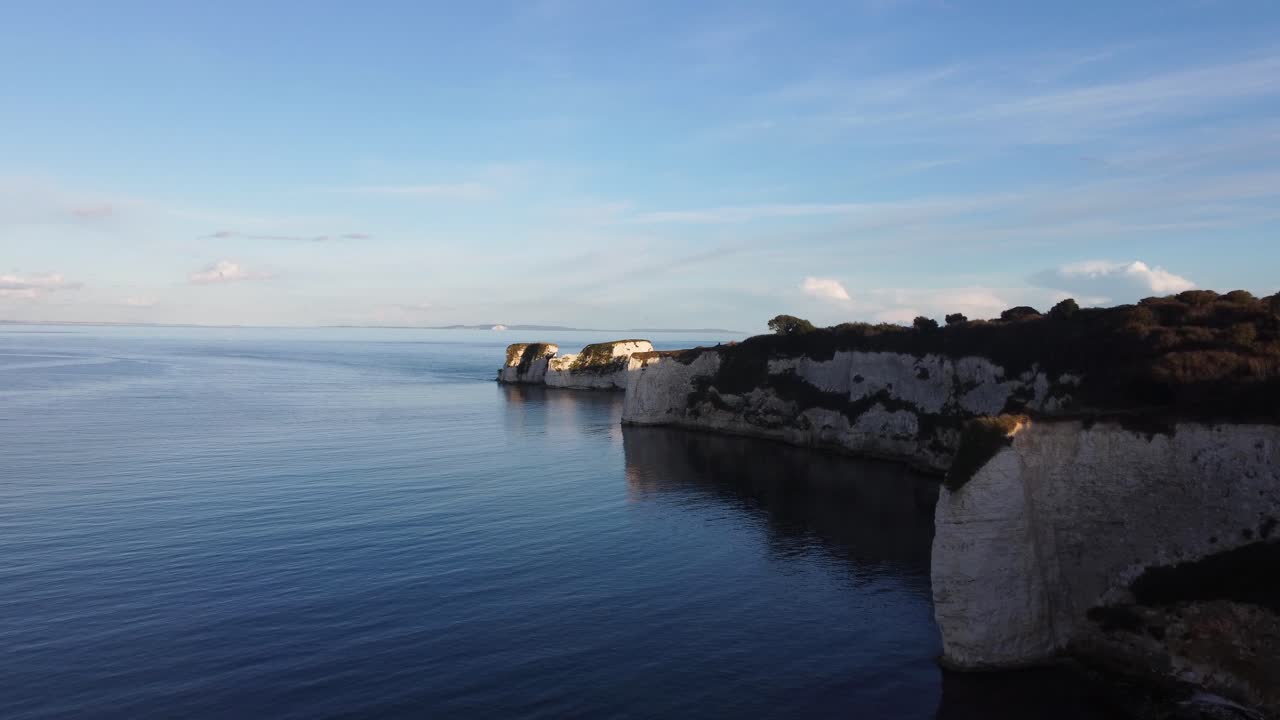 일몰 동안 영국 해안선에 있는 도싯에 있는 오래된 해리 바위 절벽의 4k 공중 파노라마 풍경 드론 샷