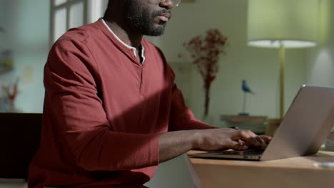 african american man working on laptop at home