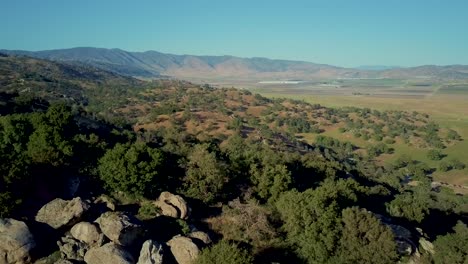 aerial dolly zoom, green valley surrounded by foothill mountains in california