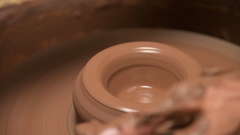 close-up of male hands making a clay bowl on a potter's wheel. handicraft and production of exclusive tea ware made of clay