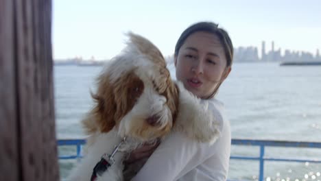 young woman holding dog on ocean pier in north vancouver