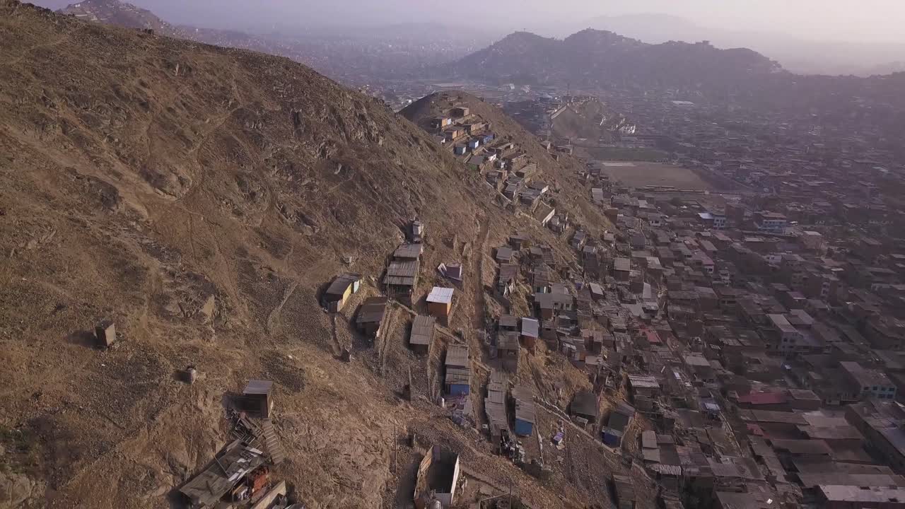 Rustic hillside homes contrast with the dense urban landscape below. A striking aerial perspective on urbanization, poverty, and social inequality. Ideal for documentary, editorial, and research use.