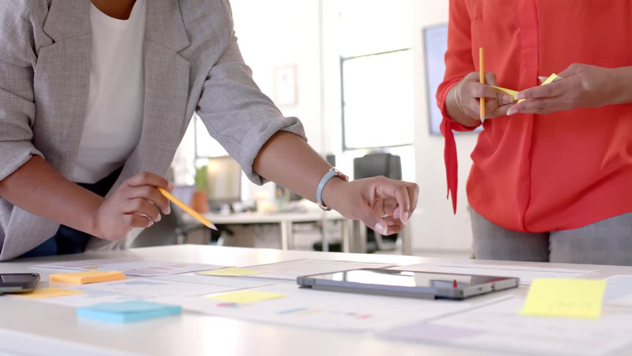diversas compañeras de negocios haciendo una lluvia de ideas usando notas y tableta en la oficina, cámara lenta