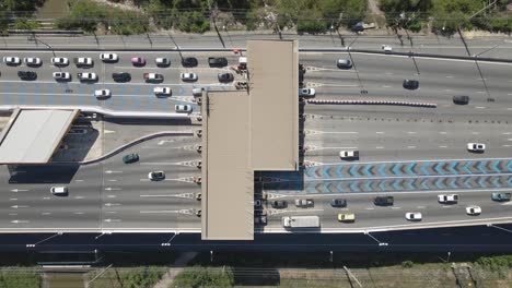 Vista-Aérea-De-Arriba-Hacia-Abajo-De-Los-Automóviles-Que-Pasan-Por-La-Puerta-De-Enlace-De-Peaje-En-La-Carretera-De-Varios-Carriles