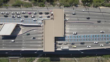 vista aérea de arriba hacia abajo de los automóviles que pasan por la puerta de peaje en la carretera de varios carriles