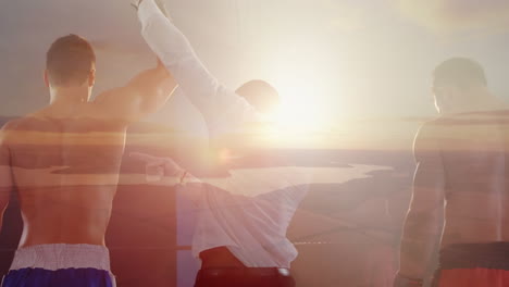 composite of two boxers and referee raising arm of victor, with sunset over lake and countryside