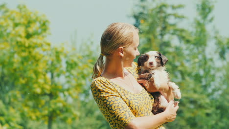 Portrait-Of-An-Adult-Woman-With-A-Puppy-Wet-Together-In-The-Summer-Rain