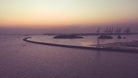 Cielos-Anaranjados-Del-Atardecer-En-El-Horizonte-Con-El-Puerto-De-Karachi-Visto-Desde-La-Playa-Con-Vistas-Al-Mar