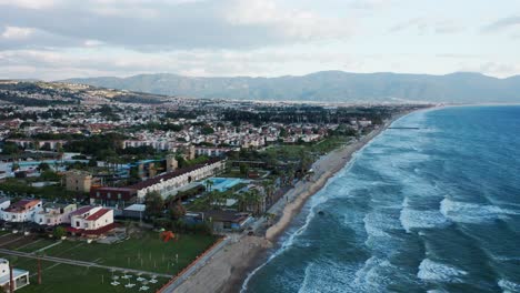 Aerial-view-of-amazing-coastal-scenery,-resort-town-of-Kusadasi,-Turkey-and-long-sandy-beach,-calm-seaside