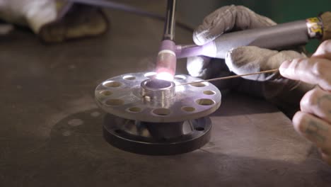 close up of man tig welding a spindal