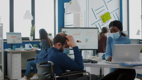 diverse coworkers with face masks working together in new normal workplace