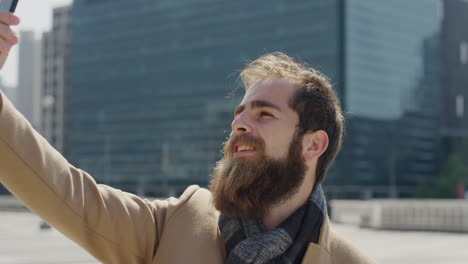 portrait attractive young hipster man using smartphone taking selfie photo smiling enjoying beautiful sunny day in city slow motion