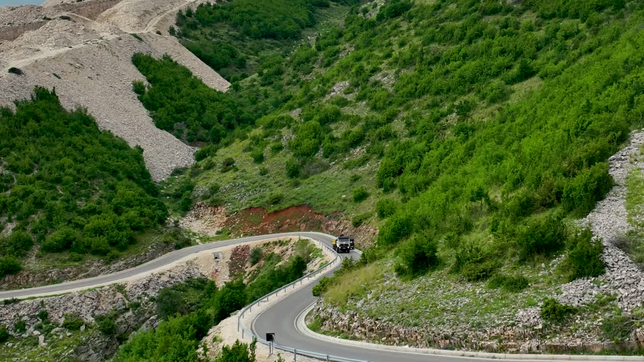 건설 현장으로 가는 산길을 따라 운전하는 트럭