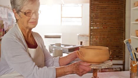 Female-potter-smiling-in-pottery-shop