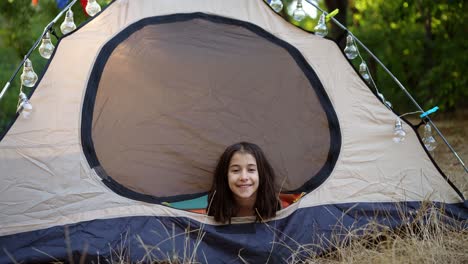 girl smiling in a tent in a camping area