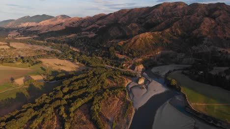 Scenic-drone-flight-over-beautiful-countryside-on-summer-sunset-during-golden-hour-in-colorful-romantic-hillside-4K