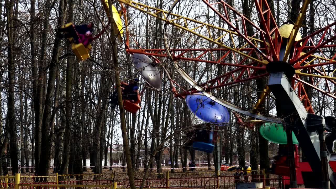 la rotonda con la gente gira en el parque de atracciones. la vieja rueda gigante gira rápidamente en primavera.