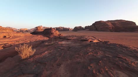 arid and rocky landscape, sunset, mountains at the background, clear sky, wadi rum, desert, jordan, traveling shot