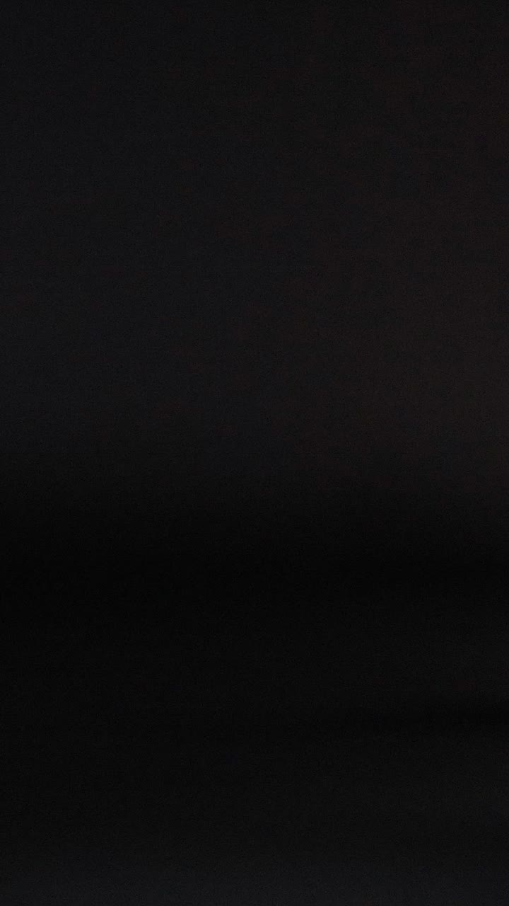 una pelota amarilla rebota contra un fondo oscuro