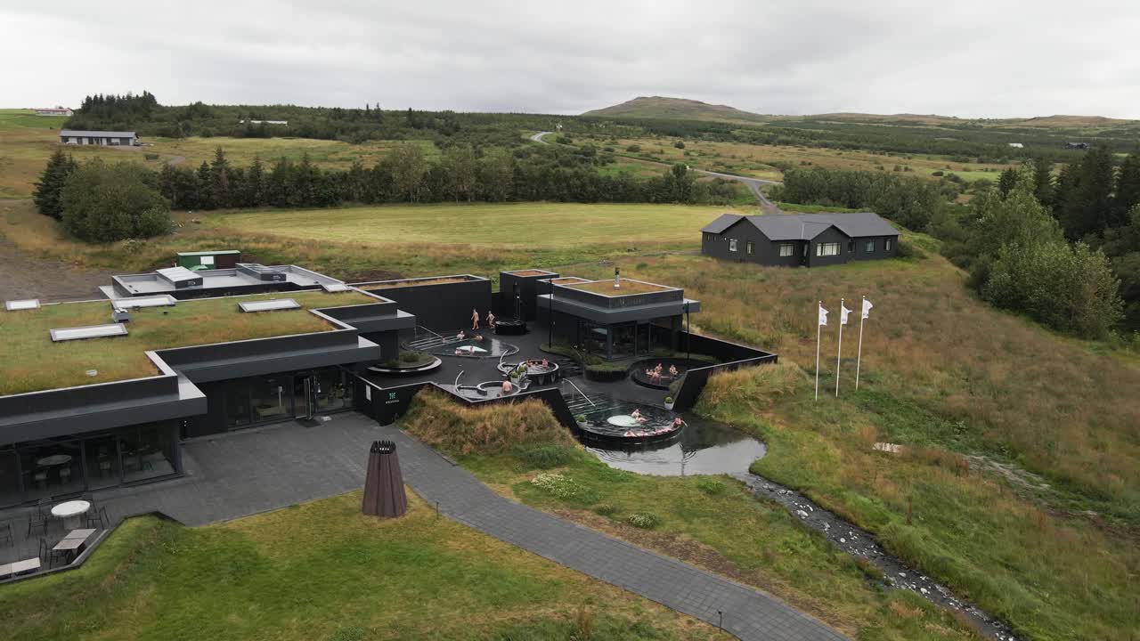 Experience tranquility from above with this 4K drone view of Krauma Baths, showcasing blissful visitors indulging in the geothermal spa pools' embrace