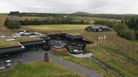 Experience-tranquility-from-above-with-this-4K-drone-view-of-Krauma-Baths,-showcasing-blissful-visitors-indulging-in-the-geothermal-spa-pools'-embrace