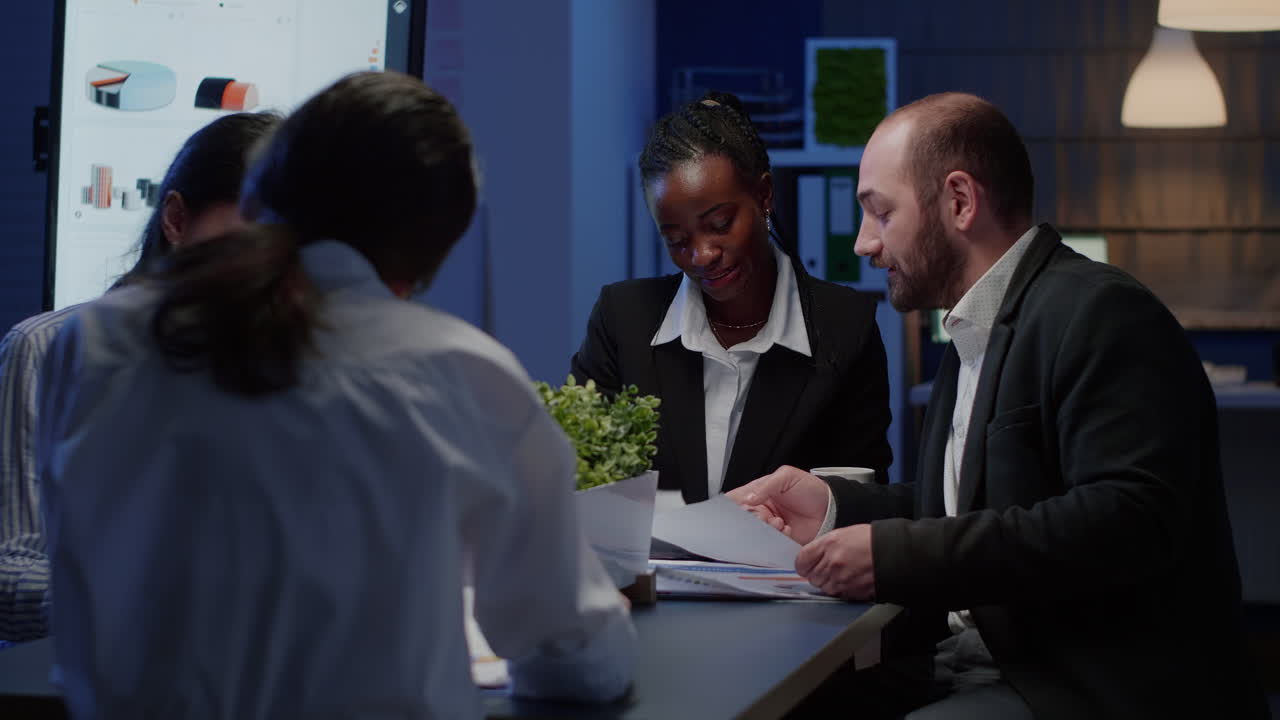 Diverse business coworkers sharing management presentation paperwork