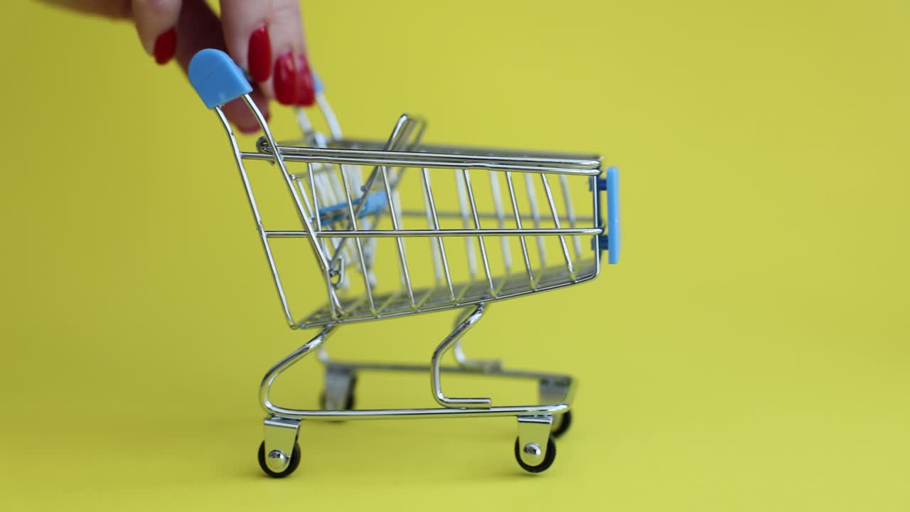 Miniature Shopping Cart on Yellow Background