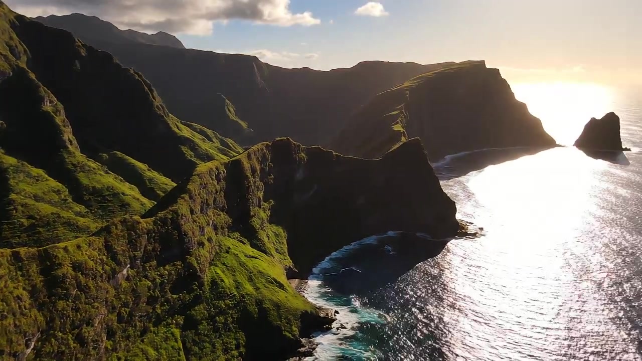 Vista aérea de falésias costeiras montanhosas verdejantes ao pôr do sol