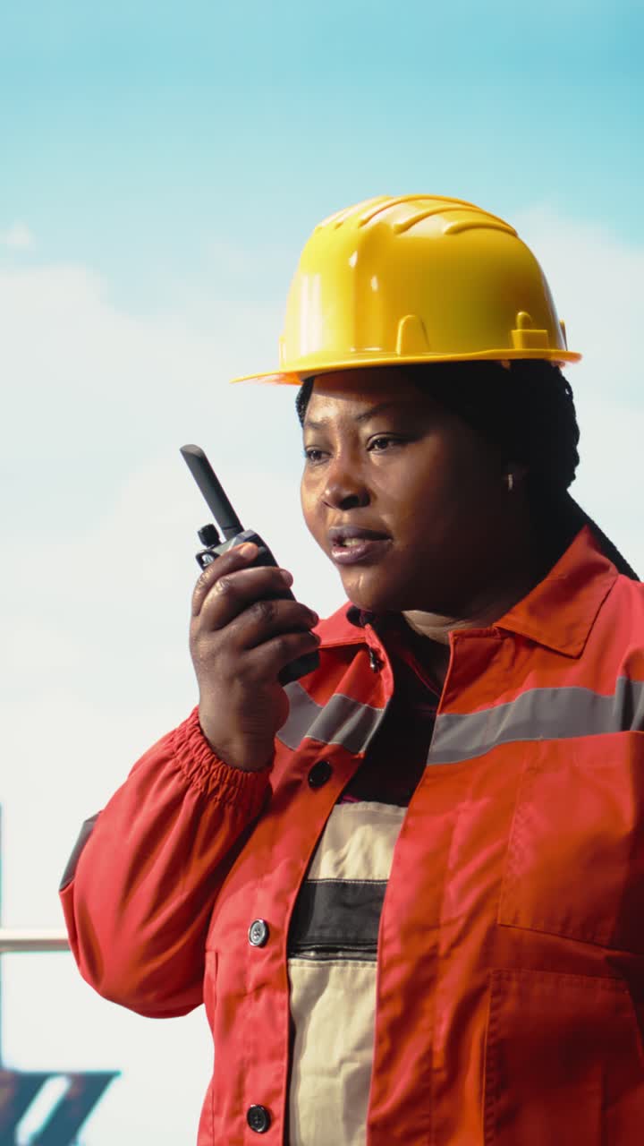 Vertical video Portrait of smiling drilling rig expert talking in walkie talkie